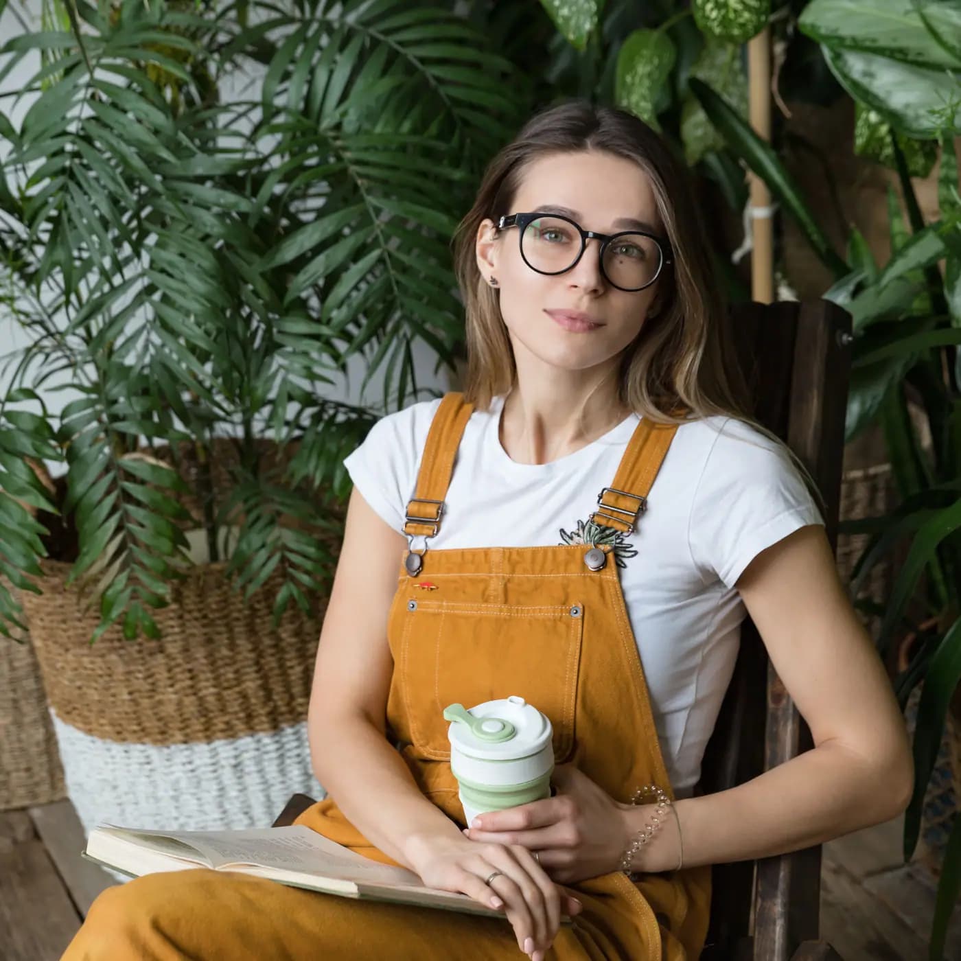Reader enjoying a published book in a calm, plant-filled reading nook